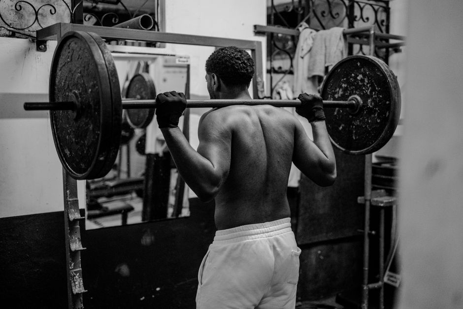 An athlete performing a heavy barbell squat in black and white.